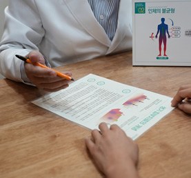 생기한의원에서 자료를 보며 치료 내용을 설명하는 장면